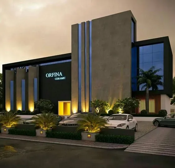 Orfina Ceramic showroom with dark cladding, vertical light slots and landscaped forecourt at night